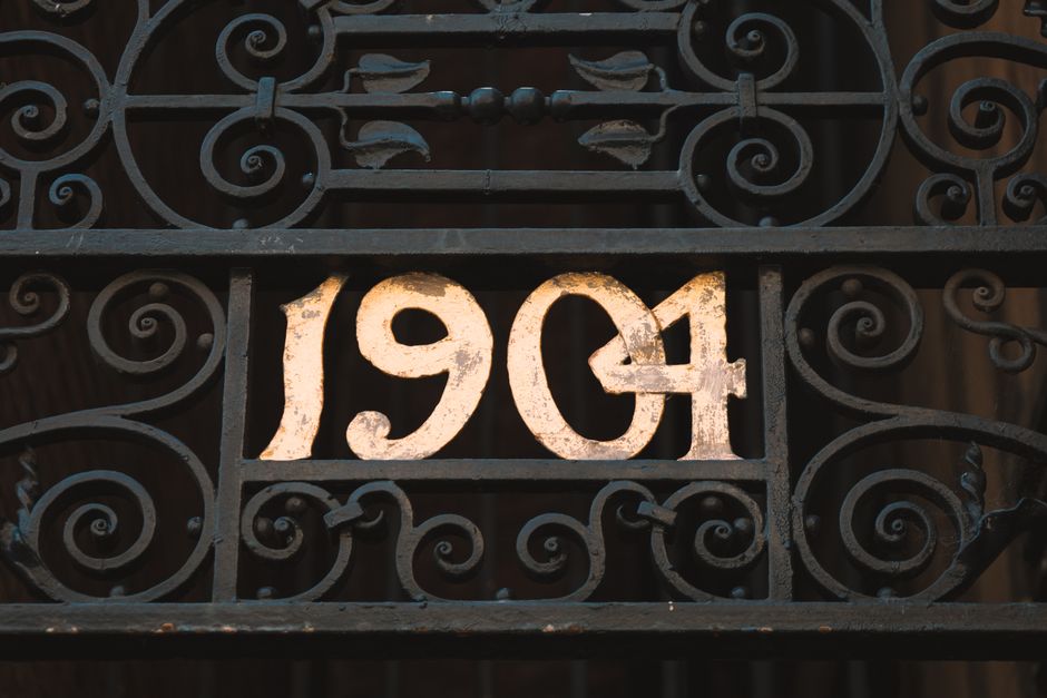 A dark metal gate with scrollwork panels