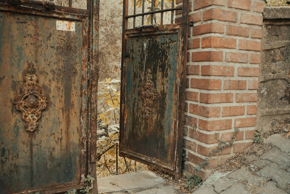 A dark metal gate with scrollwork panels